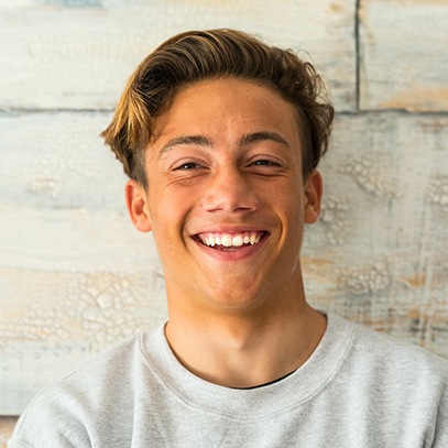 Teenage boy smiling with a dental bridge in Arlington Heights