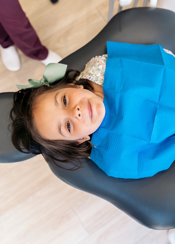 Smiling child sitting back in dental chair and smiling