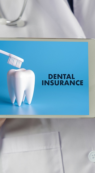 Dentist holding tablet that reads Dental Insurance