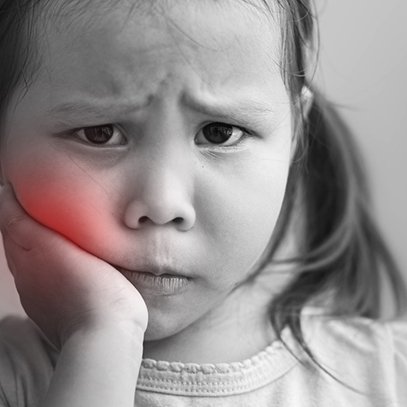 Little girl holding cheek in need of pulp treatment in Arlington Heights