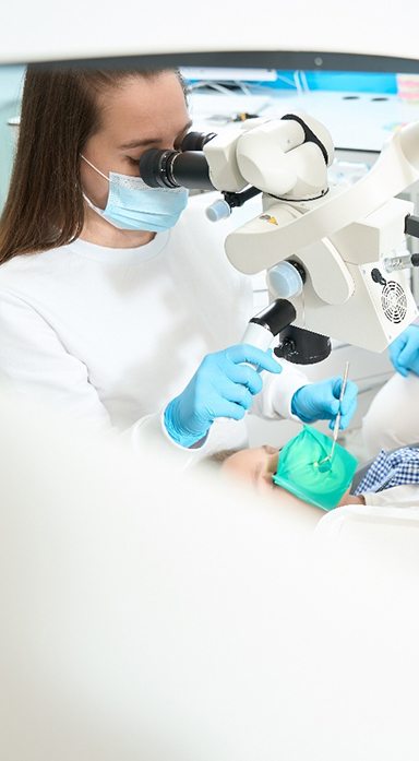 Dentist performing pulp treatment on young patient