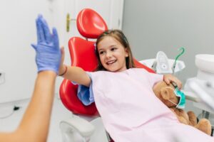 Child high-fiving her dentist